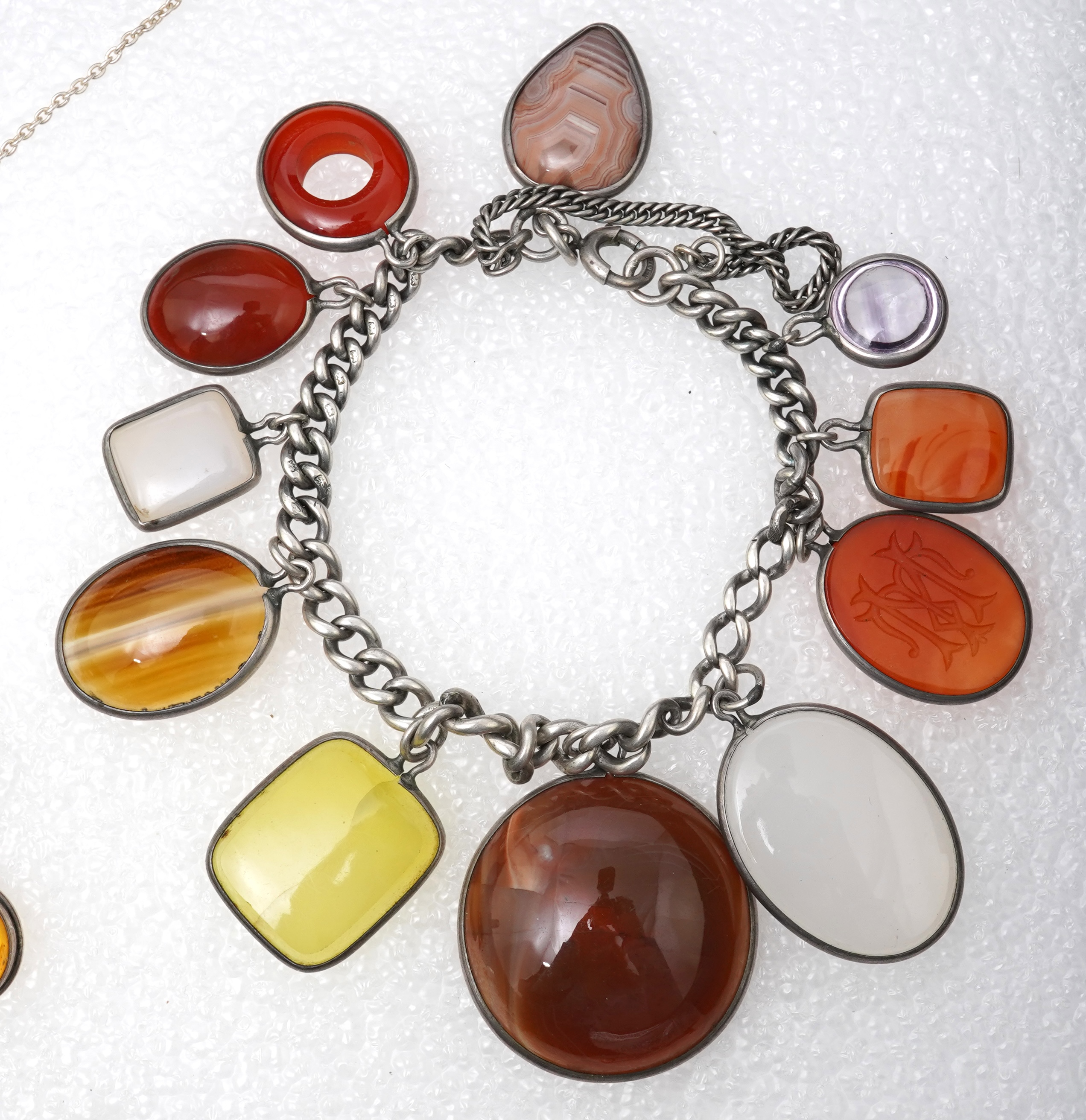 A small collection of costume jewellery to include a silver curb link charm bracelet, hung with assorted bezel set agate and carnelian drops, together with other silver and costume jewellery